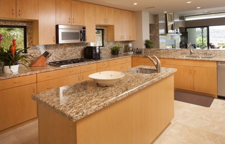 A kitchen with granite counter tops and wooden cabinets.