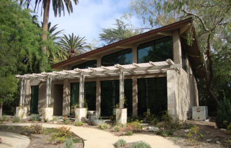 A house with a large pergola in the middle of it.