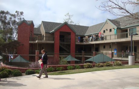 A person walking on the sidewalk near a building.