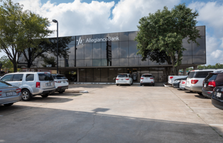 A parking lot with several cars parked in front of the building.