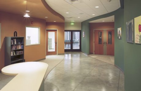 A large lobby with a television and a wall of doors.