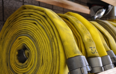A close up of three yellow fire hoses