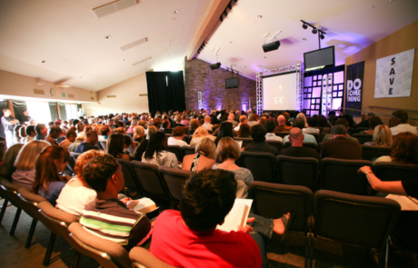 A large group of people sitting in chairs at a church.