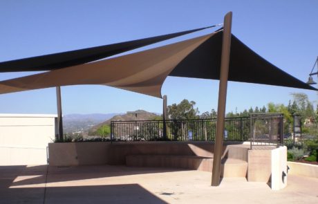 A large shade structure in the middle of a park.