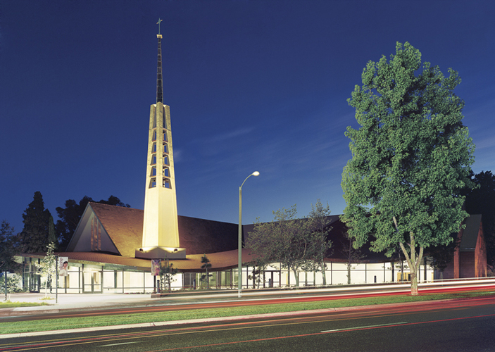 A church with a large steeple at night.
