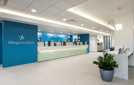 A large lobby with a reception desk and plants.