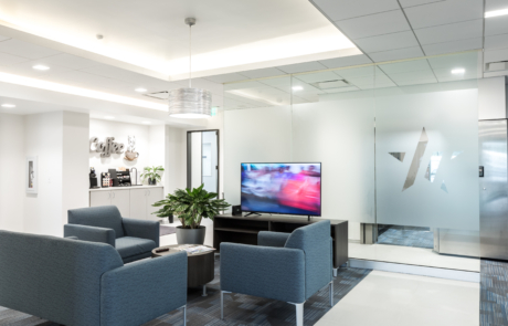 A living room with blue chairs and a television.