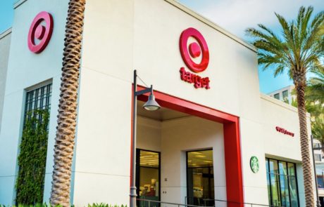 A starbucks and target store in front of a palm tree.